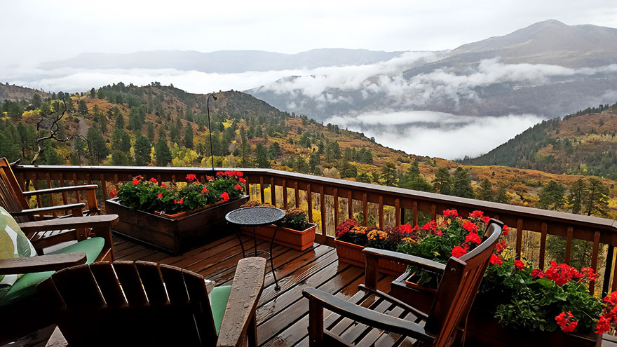 Beautiful scenery with a mountain view, wooden deck, and colorful flowers creating a serene and captivating atmosphere.