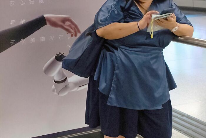 Woman in blue dress appears to have robot arms in a lucky accident captured by photographer Edas Wong.