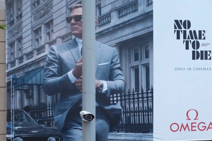 Man in gray suit and sunglasses obscured by pole in a lucky accident photo captured by photographer Edas Wong.