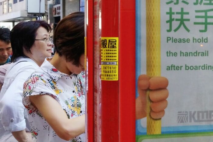 A lucky accident captured by photographer Edas Wong shows a hand perfectly aligned with a handrail safety sign.