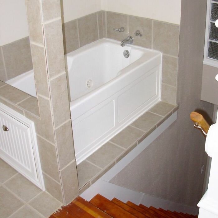 Awful home interior with a bathtub dangerously placed at the top of a staircase.
