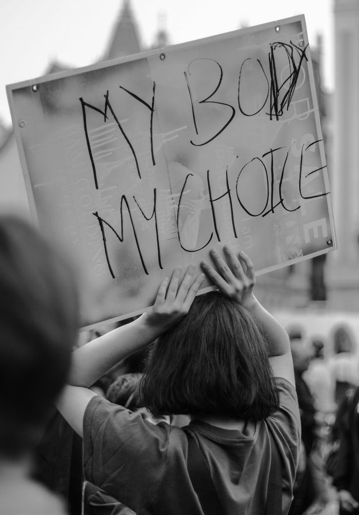 Person holding a protest sign about women's rights, illustrating times men did not understand simple things about women.