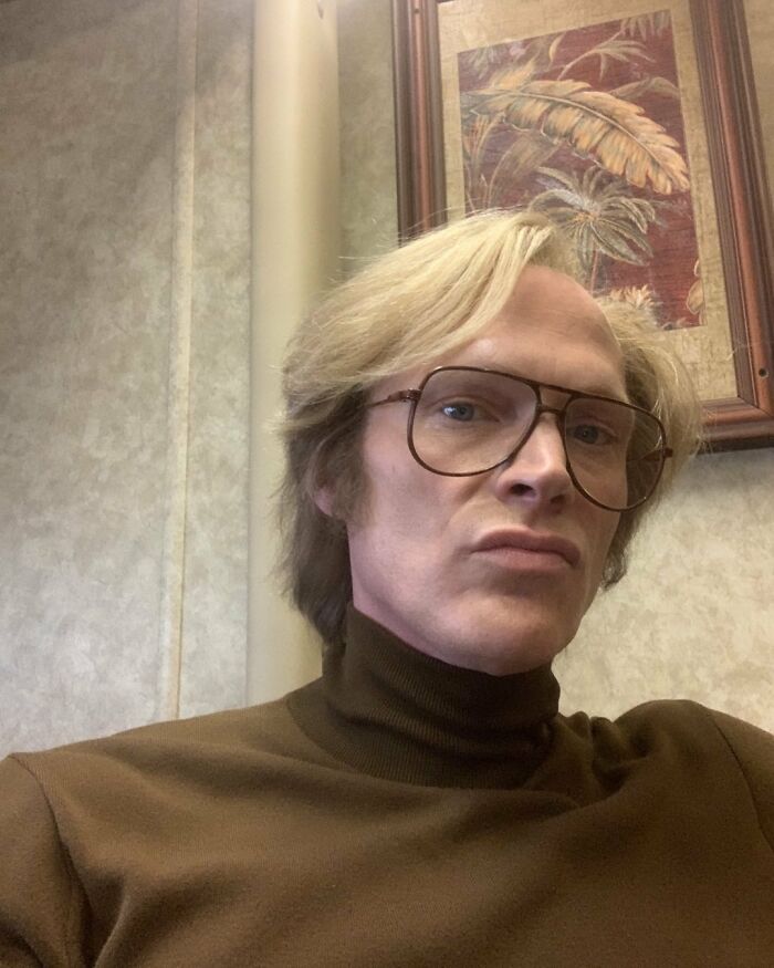 Man with blonde hair and vintage glasses wearing a brown turtleneck, portraying an actor who revived career with a single role.