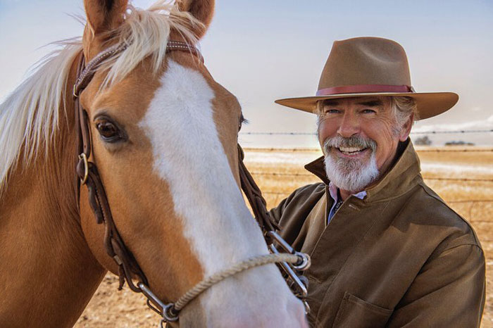 Smiling older man in a brown hat and jacket standing beside a horse, illustrating actors who revived their careers.