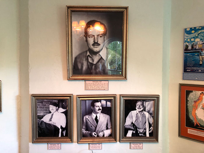 Framed black and white photos of a man displayed on a wall, illustrating conspiracies proven to be real.
