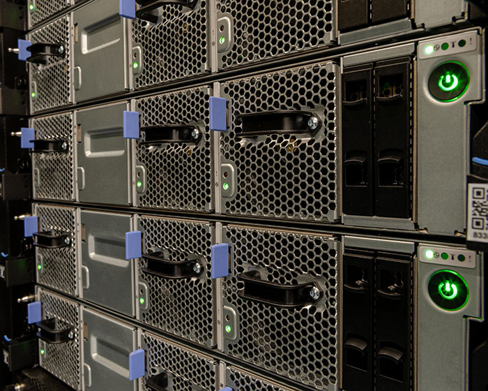 Close-up of data servers with glowing power buttons in a secure rack, illustrating digital conspiracy research technology.