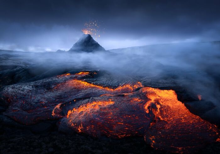 Lava flowing from erupting volcano, captured in dramatic low light landscape by Budapest International Photo Awards winners.