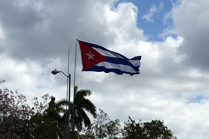 Cuban flag flying against cloudy sky, illustrating one of the conspiracies that were proven to be real online.
