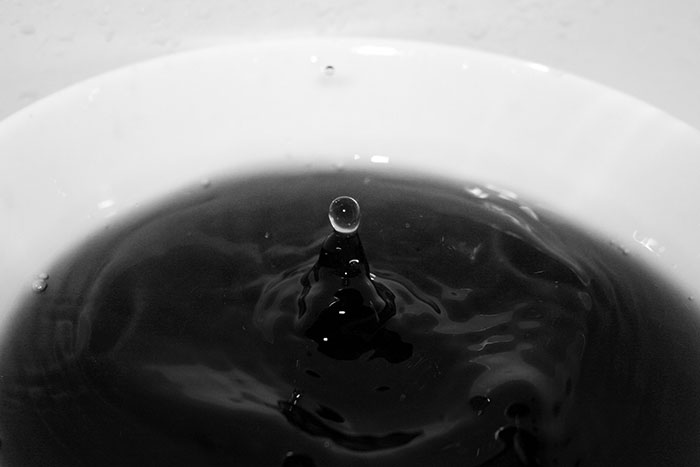 Close-up of a water droplet splash in a dark liquid, symbolizing deep sea divers sharing horrifying underwater experiences.