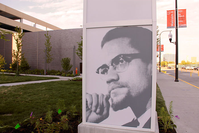 Black and white portrait of a man wearing glasses displayed outdoors, representing real conspiracies proven true by folks online.