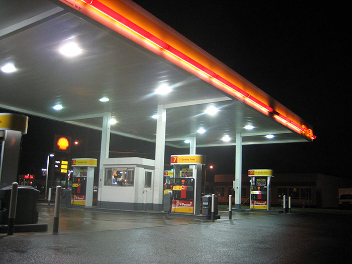 Shell gas station at night with illuminated pumps and canopy, relating to conspiracies proven to be real.