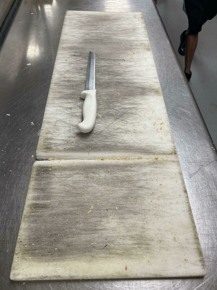 Head Chef Cutting Bread On The Same Spot. Finally Getting Through The Board