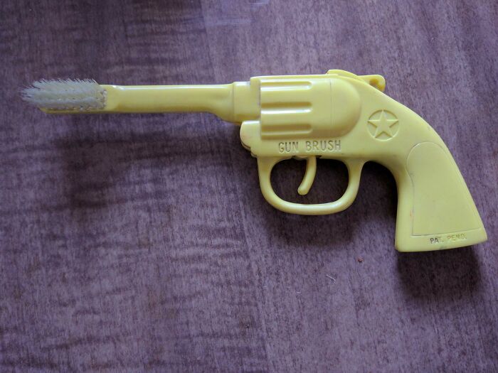 Yellow toy gun shaped toothbrush with a star detail, showcasing one of the hilariously creepy toys causing nightmares.