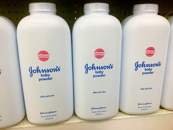 Bottles of Johnsons baby powder on a shelf highlighting conspiracies related to health and safety claims online.