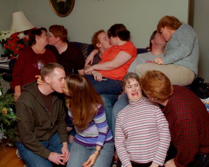 Funny couples pose humorously in a crowded room.