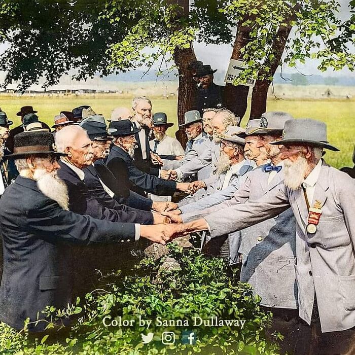 Union Blue And Confederate Gray Veterans Reunite At Gettysburg In The Year 1913 — Standing By “The Bloody Angle” Where Pickett’s Charge Took Place 50 Years Earlier And Over 3,000 Soldiers On Both Sides Lost Their Lives — Now They Clasp Hands Over The Stone Wall As Brothers