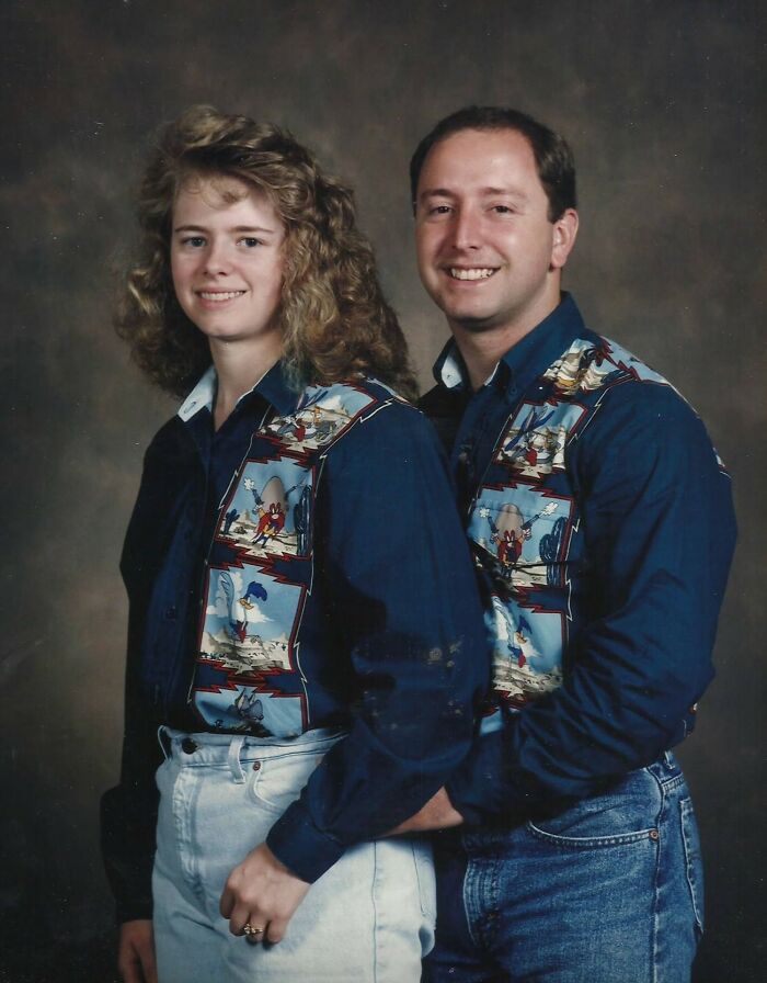 Funny couples' photo with matching cartoon vests, smiling warmly at the camera.