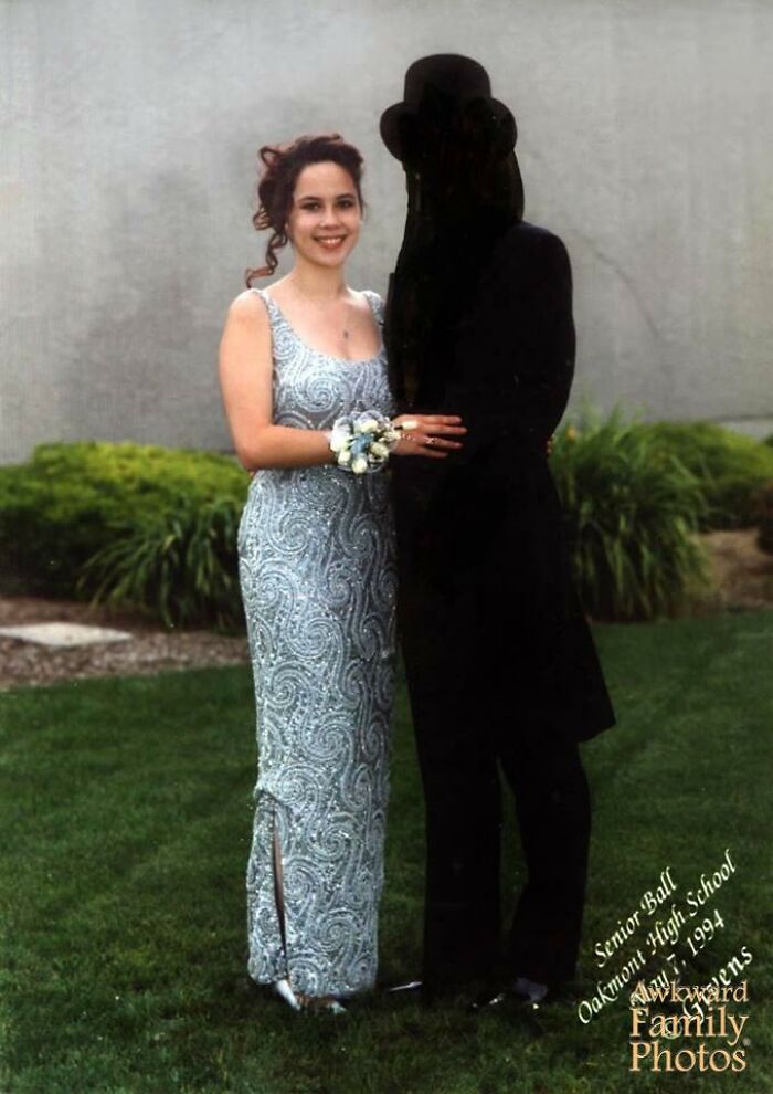 Funny couples' picture with a woman in a silver dress and a mysterious partner in a black outfit at a high school dance.