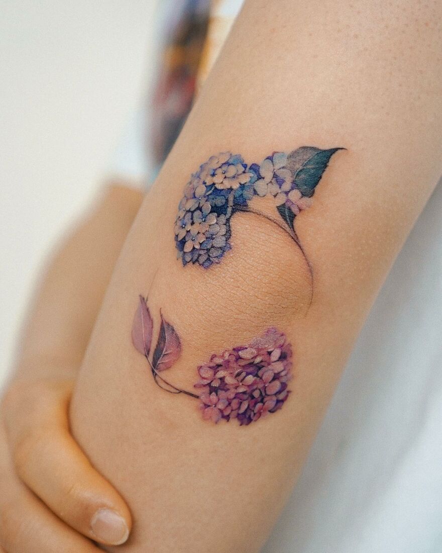 Painting-like tattoo of hydrangeas on an arm, showcasing delicate floral artistry.