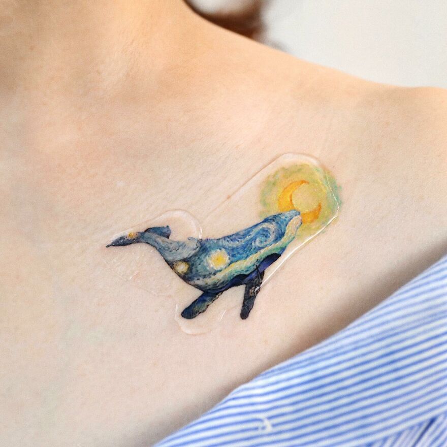 Painting-like tattoo of a whale on a shoulder, featuring vivid colors and artistic details.