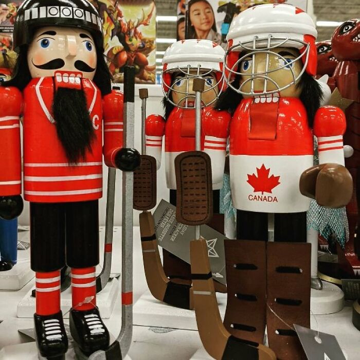 Canadian-themed nutcrackers dressed as hockey players, featuring the iconic maple leaf, humorously highlight stereotypes.