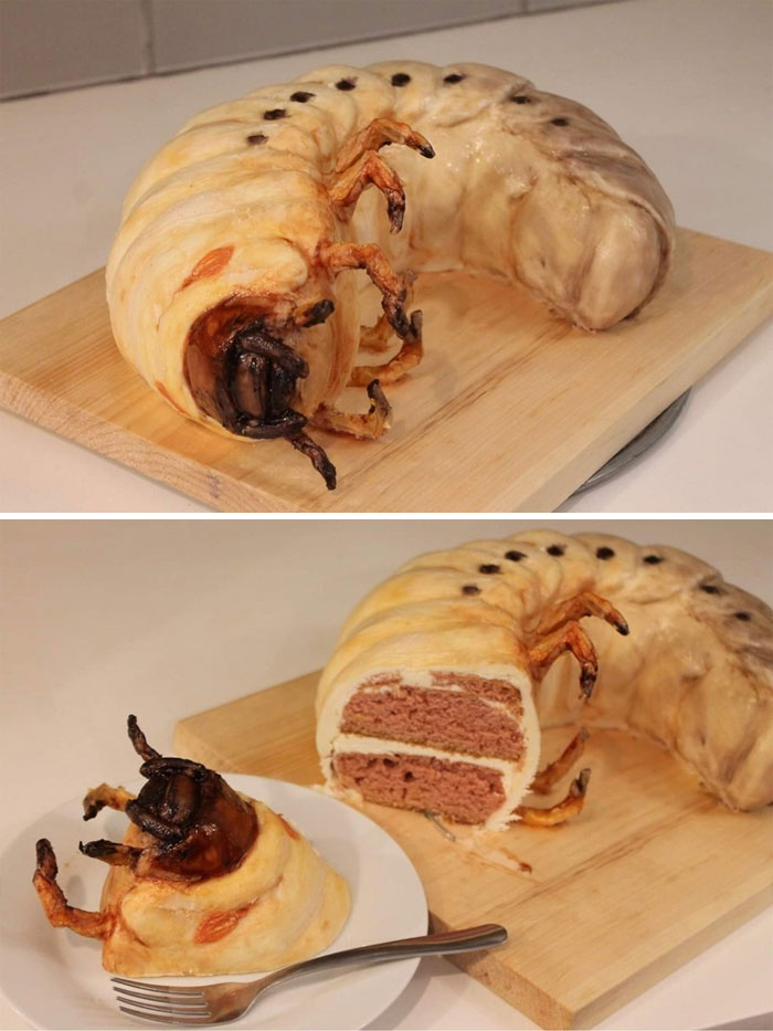 Cursed food: cake shaped like a giant grub with realistic details, sliced to reveal layers inside.