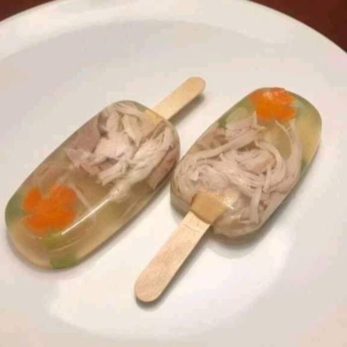Cursed food: chicken and vegetable popsicles on a plate.