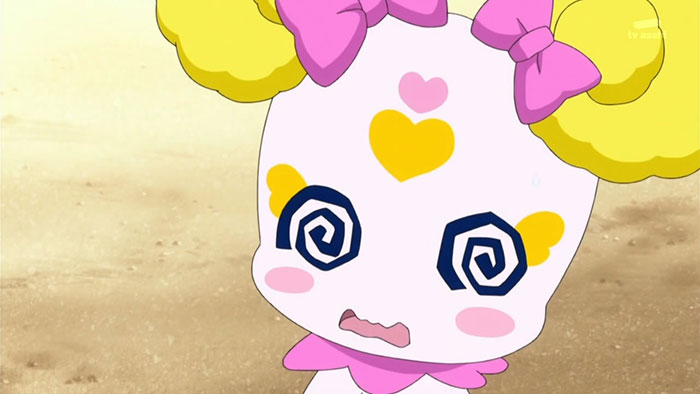 Cute animated character with yellow pigtails and pink bows, expressing surprise with spiral eyes and a heart on its forehead.