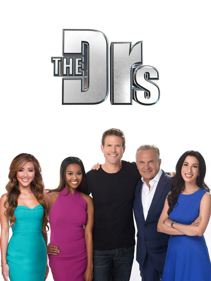 TV show's medical experts smiling, standing together in colorful outfits.