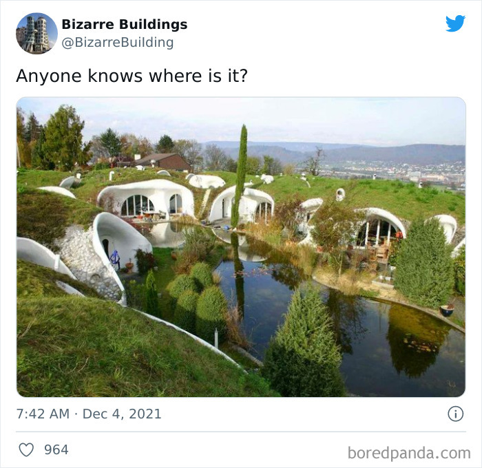 Unusual architect-designed homes built into a hillside with curved white structures and a central pond, unique but uncomfortable buildings.