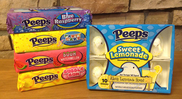 Assorted Peeps marshmallow candy packs stacked on a table, showcasing various fruity flavors and colorful packaging.