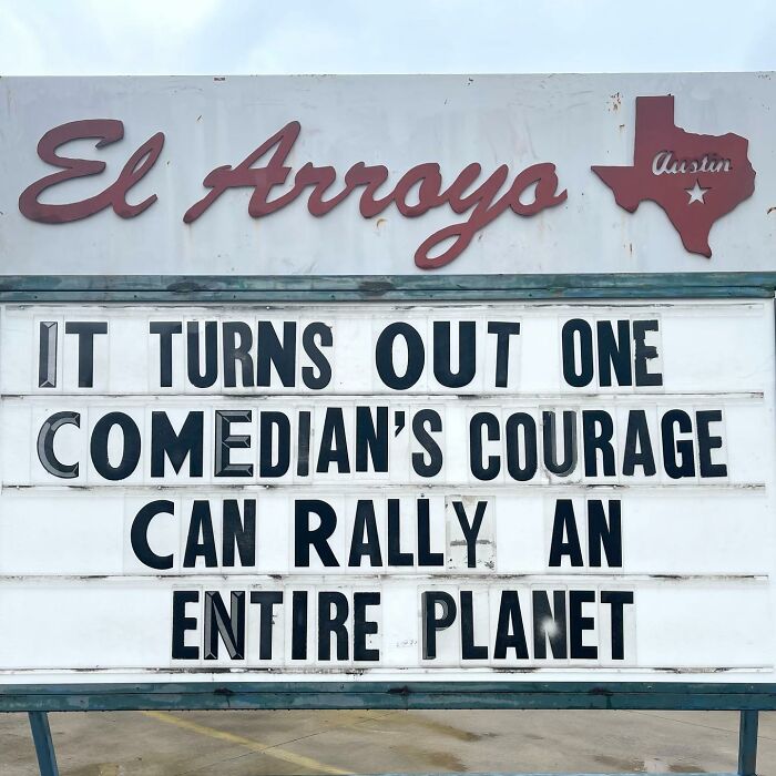 Restaurant sign reads: "It turns out one comedian's courage can rally an entire planet," showcasing humor.