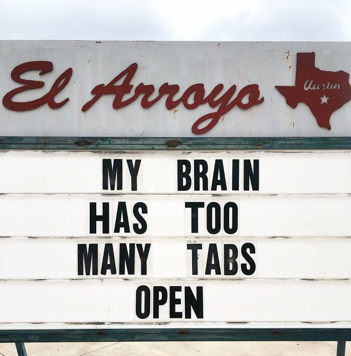 Restaurant sign saying, "My brain has too many tabs open," showing humor in public message.