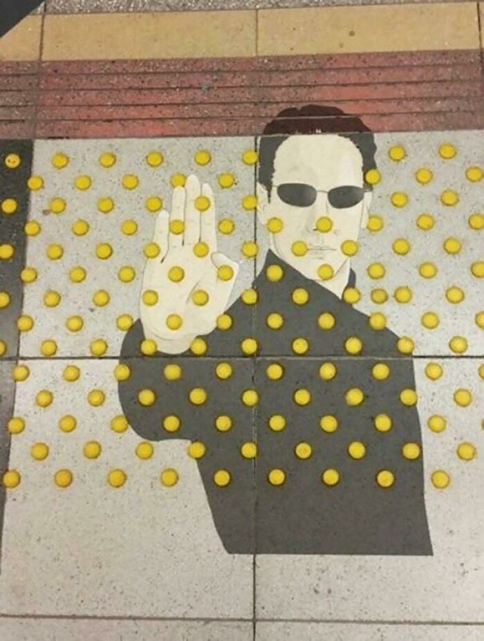 Me parece más arte que vandalismo. Neo en el pavimento táctil para invidentes
