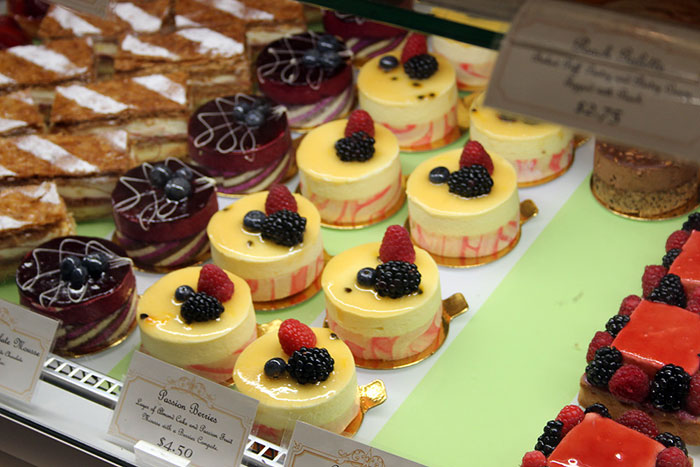 Assorted colorful pastries and desserts displayed in a bakery case, highlighting inedible foods and unusual treats.