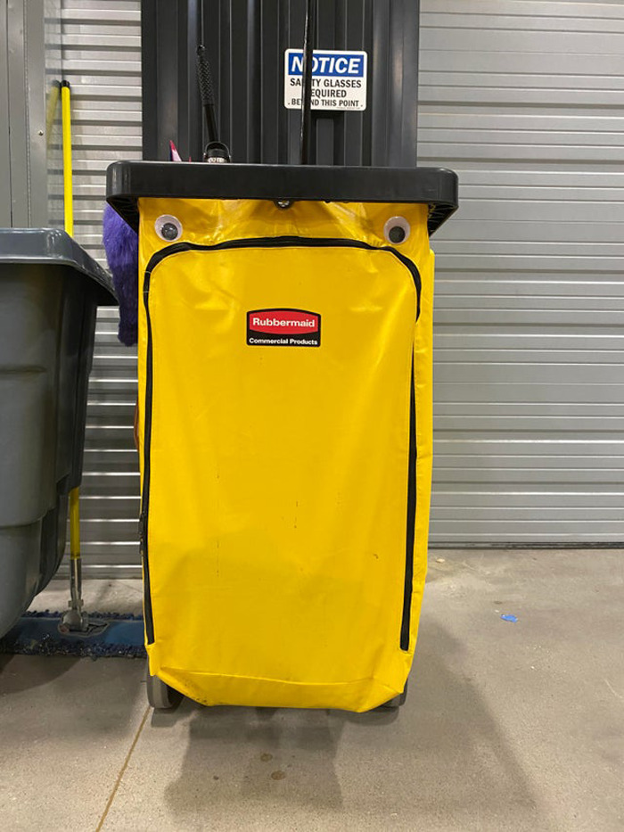 Yellow Rubbermaid cleaning cart with wiggle eyes making the object funnier in an eyebombing trend.