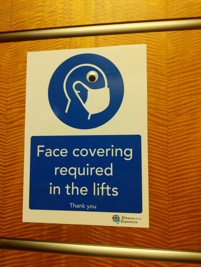 Face covering sign with wiggle eyes added, making a random object funnier in eyebombing community.