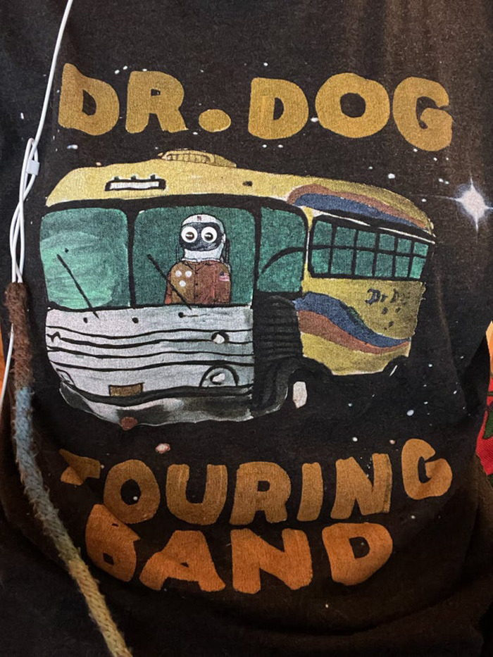 T-shirt design of a tour bus with wiggle eyes added, enhancing the random object in the eyebombing online community style.