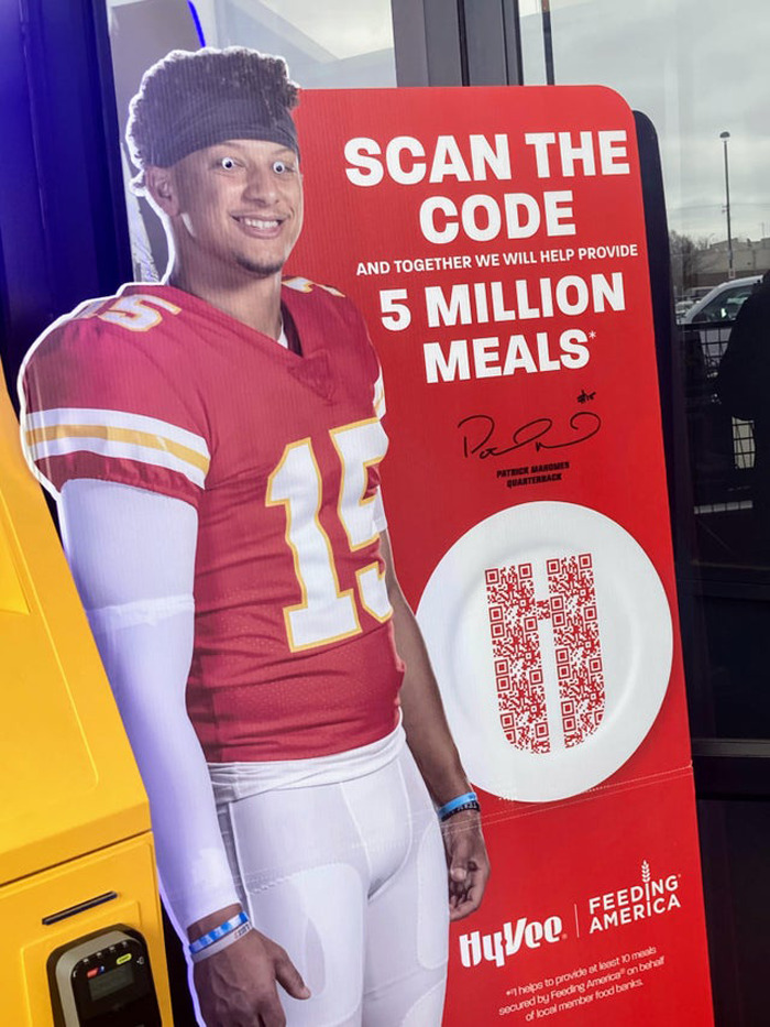 Cardboard cutout of football player with wiggle eyes added, promoting 5 million meals donation campaign.