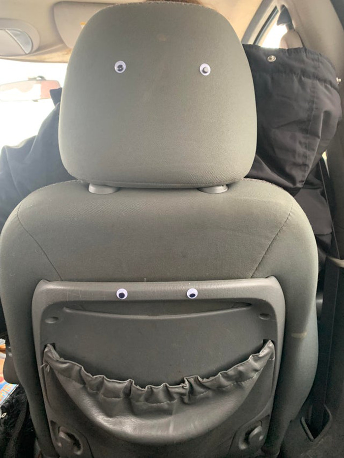 Car seat with wiggle eyes attached, humorously transforming random objects in the eyebombing online community.