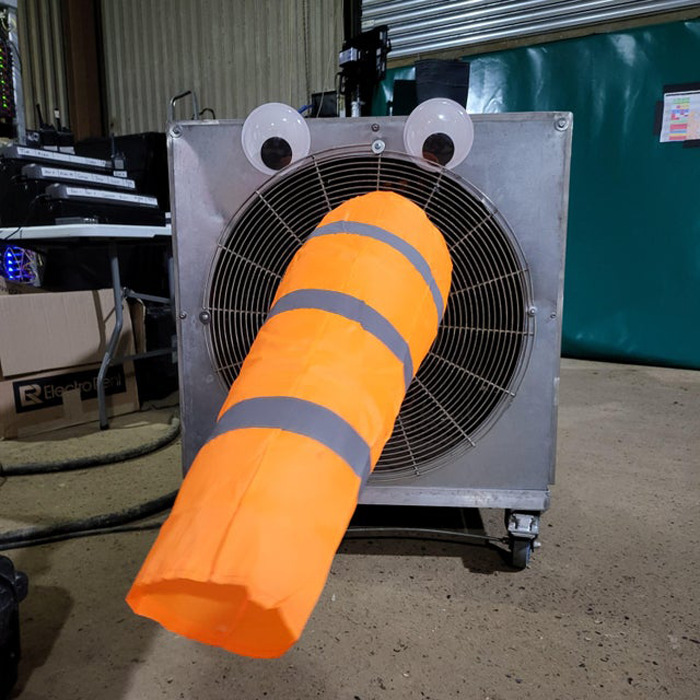 Industrial fan with wiggle eyes and bright orange cover, enhancing random objects in eyebombing community.
