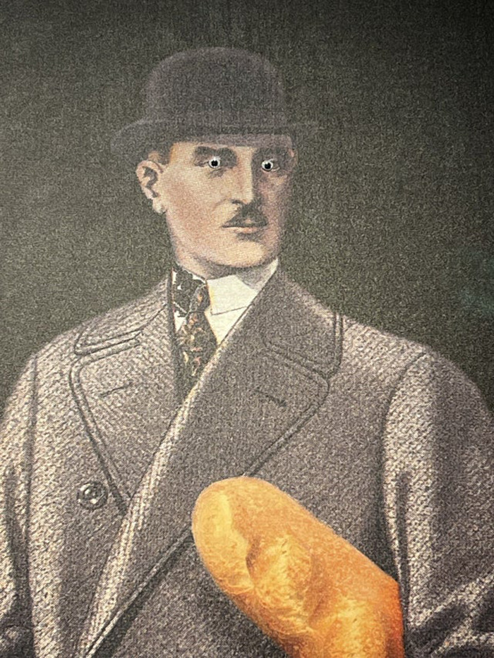Vintage man portrait with wiggle eyes added, holding a loaf of bread, showcasing creative eyebombing fun.