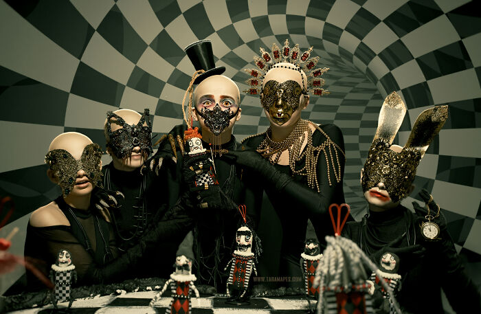 Dark Alice interpretation with masked figures and elaborate costumes in a surreal Wonderland setting.