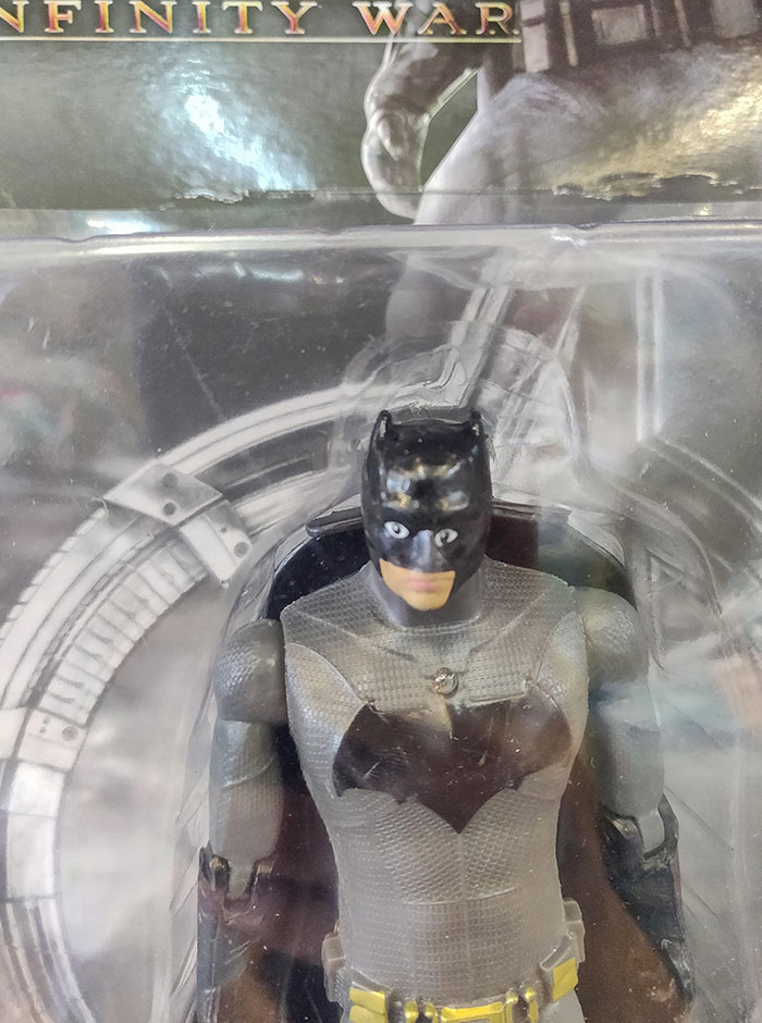 Creepy Batman action figure toy with distorted eyes inside plastic packaging, one of the hilarious nightmare-inducing toys.