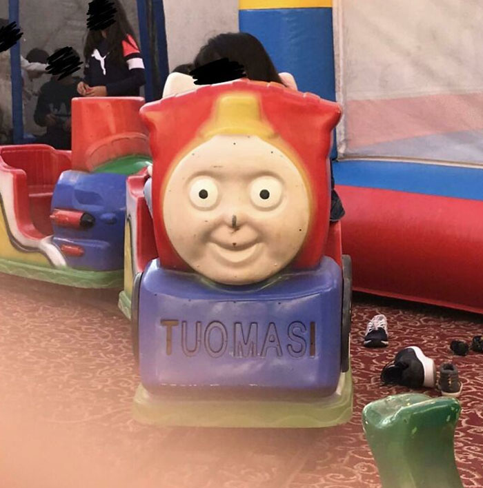 Creepy toy train with distorted face and the name "TUOMASI," part of hilariously creepy toys collection that give nightmares.