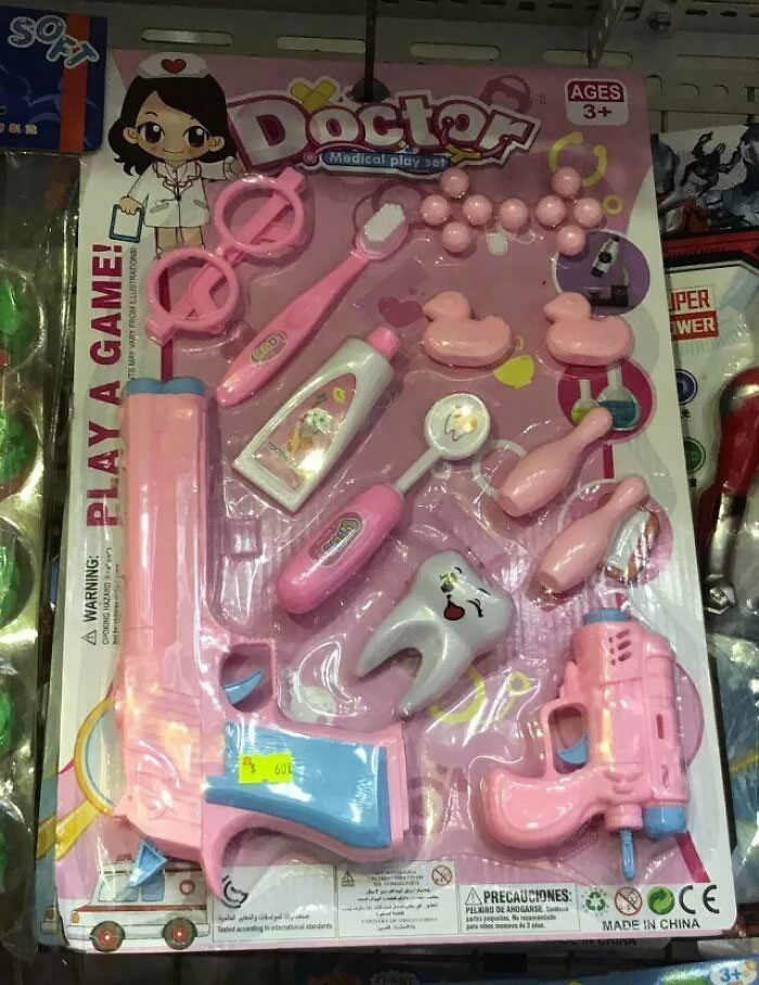 Creepy pink toy doctor set including dental tools and toy guns, blending medical play with unsettling elements.