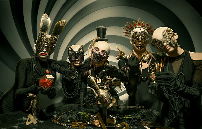Dark Alice interpretation: five masked figures in intricate costumes, surrounded by whimsical props, in a surreal setting.