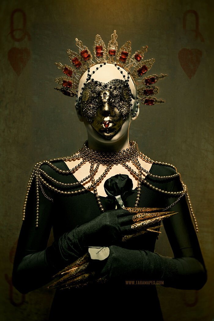 Dark Alice interpretation with ornate mask, gold details, and black gloves holding a dark rose against a moody backdrop.