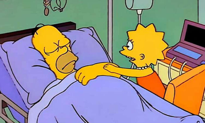Homer Simpson lying in a hospital bed with Lisa Simpson holding his hand, highlighting fan theories about Homer.