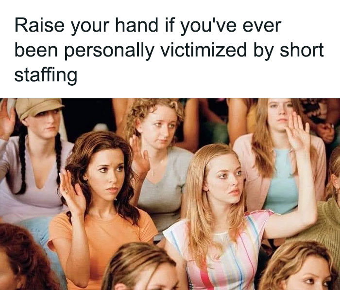 Women raising hands in a humorous meeting about short staffing, reflecting corporate humor.